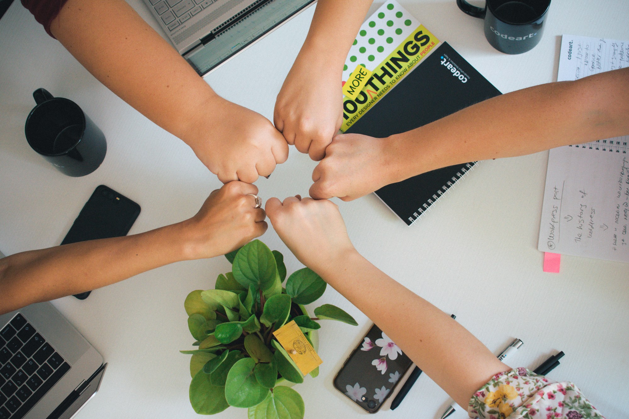 people in a circle putting their fists together to touch