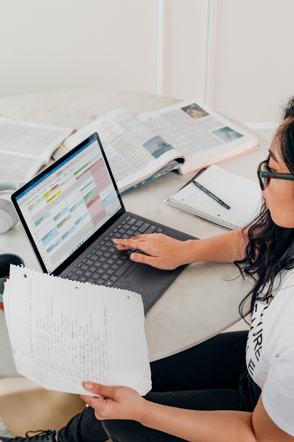 woman in white shirt using laptop